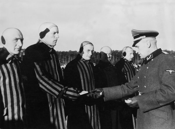 Images to fool the world: well-fed concentration camp inmates receive their cigarette rations from the SS.