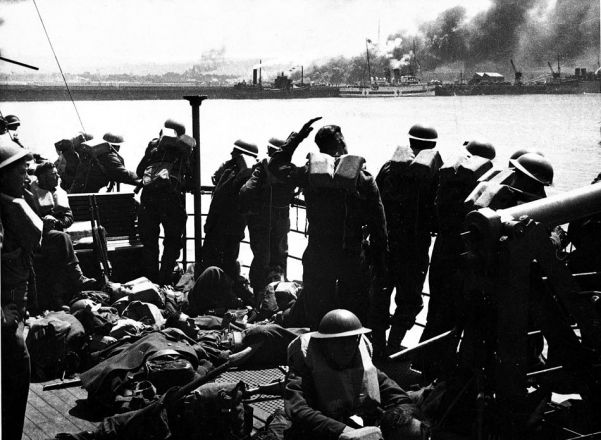 Plumes of smoke rise from Dunkirk's port area as troops sail back to Britain