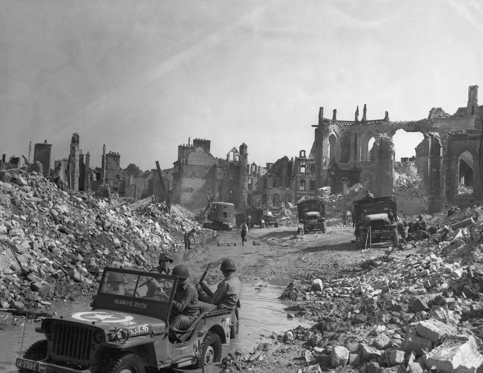 Allied troops in the ruins of Valognes during the drive against Cherbourg, which fell on June 29, 1944